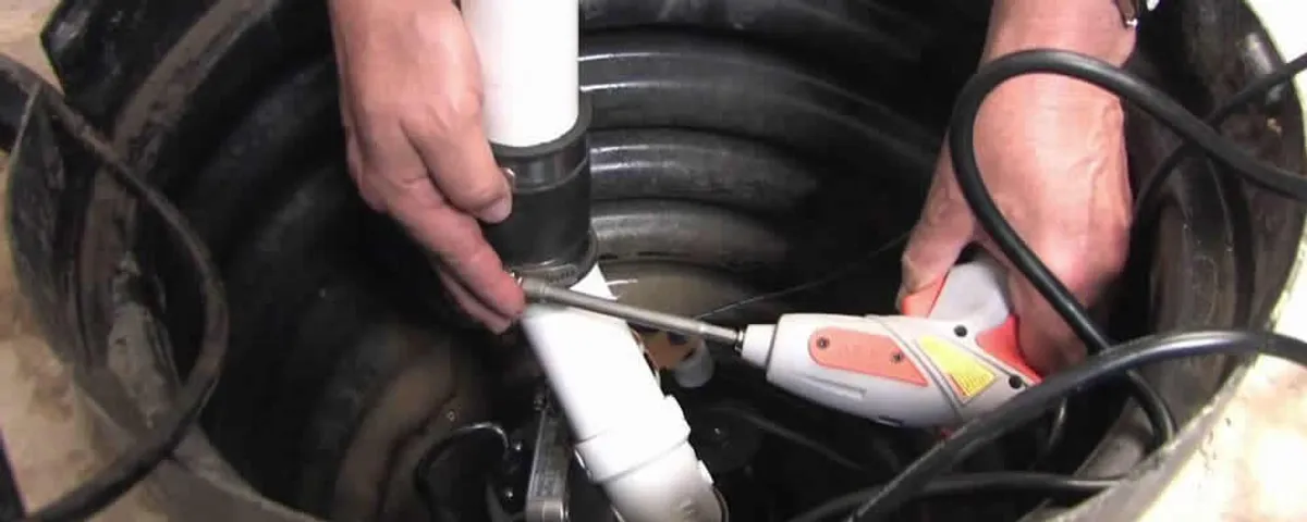 Sump pump installation technician connecting PVC discharge piping in Memphis, TN
